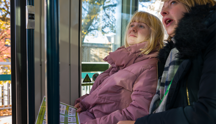 A woman and young adult using Widgit symbols guides on Nottingham Trams